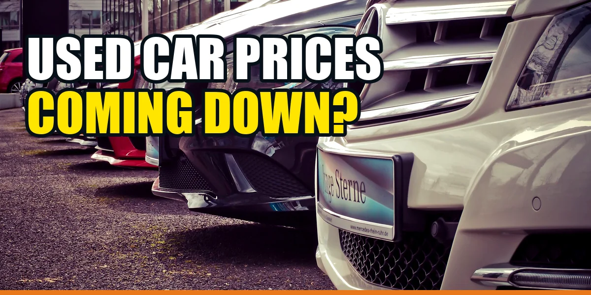 Used cars lined up at a dealership with the headline Used Car Prices Coming Down?